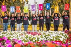 Students holding signs spelling the word Thanks.